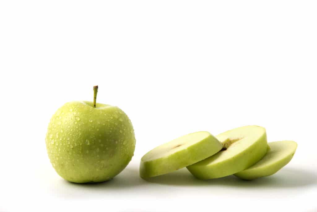Green apple whole and sliced on white background